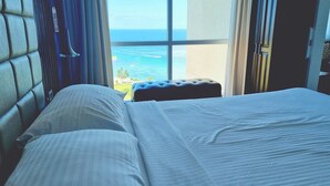 Une chambre d’hôtel avec un lit, une vue sur la mer et un balcon.