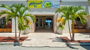 Un bar sulla spiaggia chiamato 'Sapphire', con un'insegna accogliente, palme e vista sulla spiaggia.
