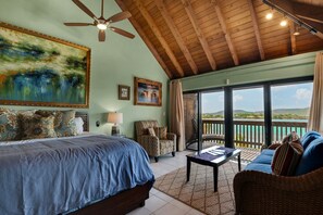 A bedroom with a large bed, a ceiling fan, a painting, a sofa, and a balcony with a view. - Luxurious, Penthouse, 2 level, corner unit Oceanfront condo at Sapphire Beach (St Thomas)