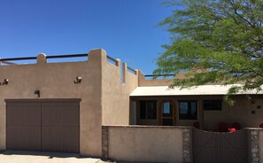 A building with a flat roof, a large garage door, and a gated entrance.