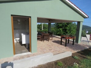 A covered patio with a table and chairs, a small table with a board game, and a view of the surrounding greenery. - Old renovated house with private swimming pool, romantic, quiet, family friendly (Labin)