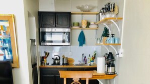 Un comedor con una mesa redonda de madera, cuatro sillas y un centro de mesa con un tazón amarillo.