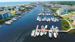 Un port de plaisance où sont amarrés de nombreux bateaux, entouré d’immeubles résidentiels et offrant une vue dégagée sur l’océan.