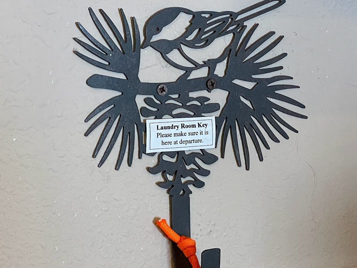 A wall-mounted key holder with a label for a laundry room key.
