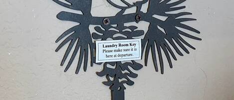 A wall-mounted key holder with a label for a laundry room key.