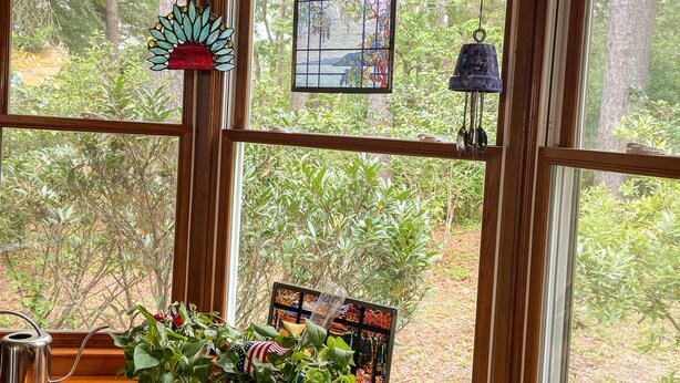 Una habitación con ventanas amplias, vigas de madera y un banco de madera.