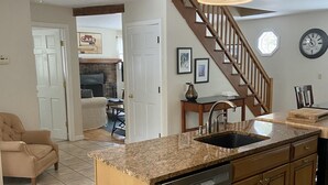 A kitchen with a built-in dishwasher, wooden cabinets, a granite countertop, and a wooden ceiling.