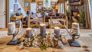 A cozy living room with a fireplace, wooden furniture, and decorative candles.
