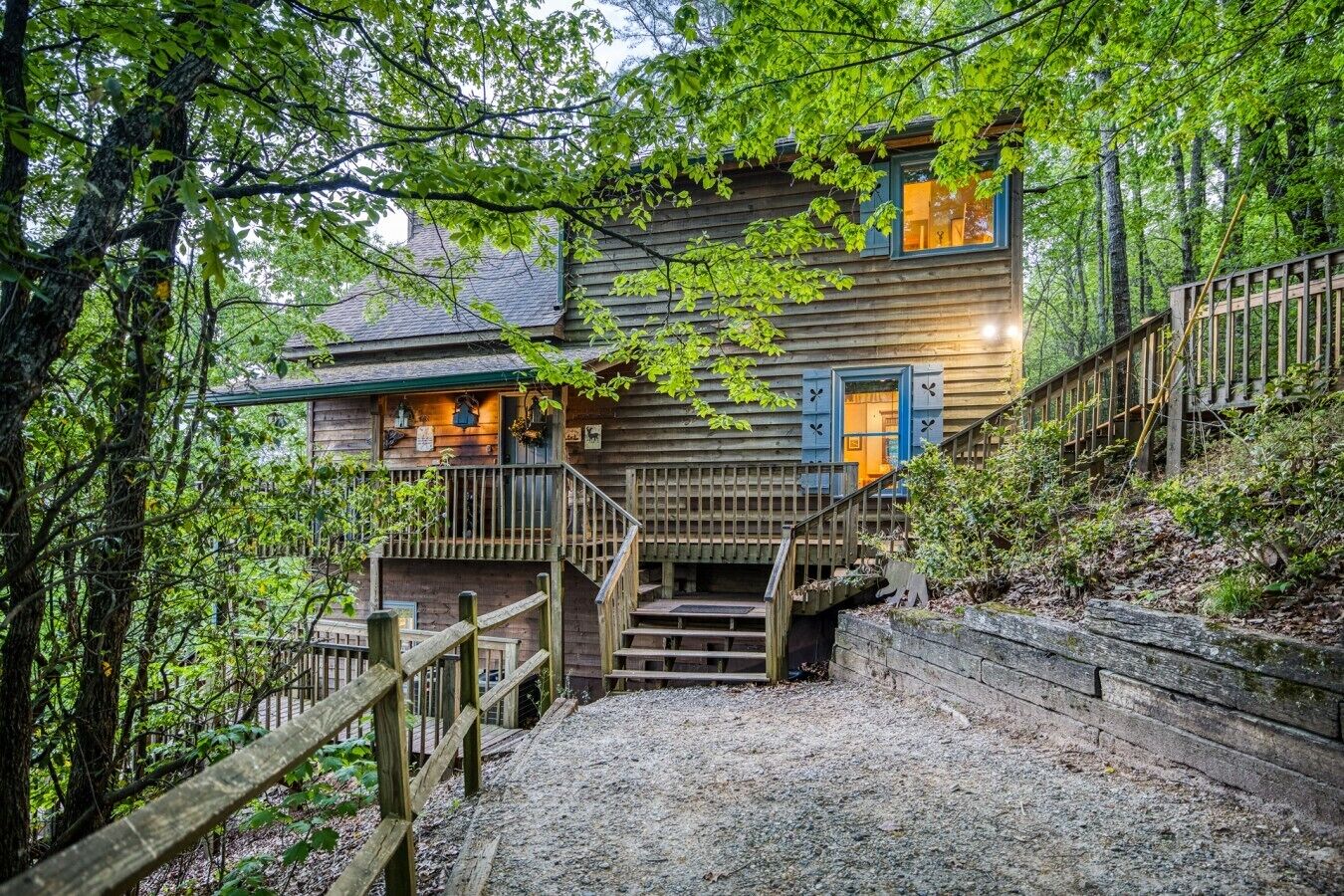 Eine Holzdiele mit einer Treppe, die zu einer Veranda führt, umgeben von Bäumen.