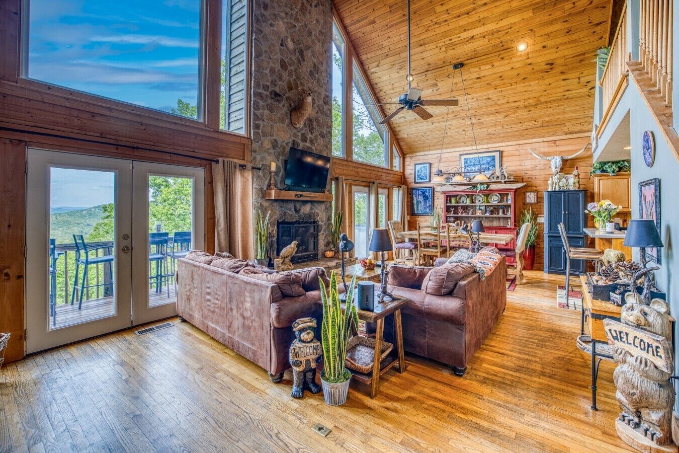 A spacious living area with a stone wall, wooden ceiling, and a fireplace.