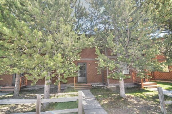A wooden house with a front porch, a small front yard, and a wooden fence. - Very nice Condominium in an excellent location! (West Yellowstone)