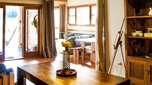 Un interior rústico con vigas de madera a la vista, una mesa de madera y un candelabro.