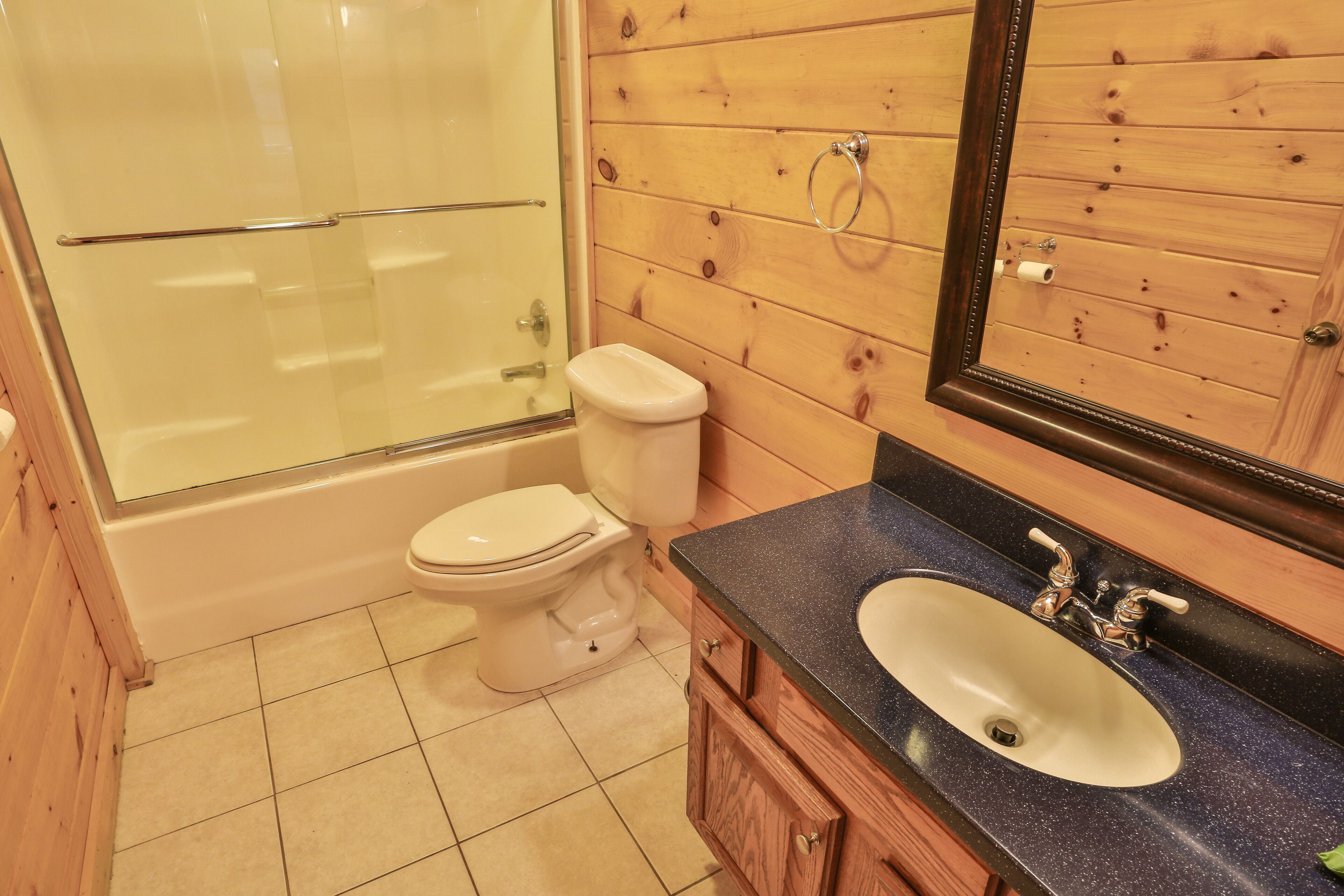 Une salle de bain avec une douche à parois de verre, des toilettes et un lavabo avec un miroir au-dessus.