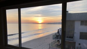 A view of a beach from a window overlooking a building with a balcony. - Sunset Malibu Road Premium Ocean Front Penthouse (Malibu)