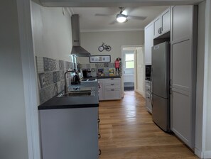 A kitchen with a stainless steel refrigerator, a built-in oven, and a gas stove. - Ride hard, Rest Easy, Sleep Well (Mount Beauty)