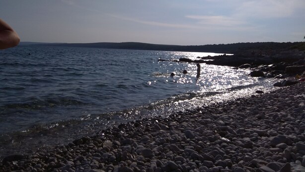 A rocky shoreline with calm water reflecting sunlight. - Apartment Laura, Viškovići, Koromačno, Istra ! near the sea!!   (Koromačno)
