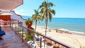 Ein Balkon mit Blick auf den Strand, Palmen und das Meer.