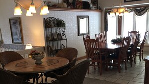 A dining area with a round table, chairs, and a chandelier.