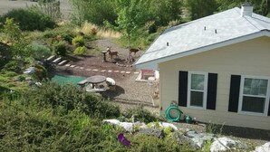 Ett hus med en trädgård, en pool och en bergskedja i bakgrunden.