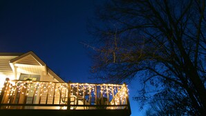 Une maison dotée d’un balcon décoré de guirlandes lumineuses.