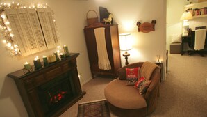 Un salon chaleureux avec une cheminée, un canapé, un tapis et une lampe.