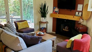Ein Wohnzimmer mit einer Couch, einem Sessel, einem Couchtisch und einem Kamin.