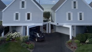 En toetages boligbygning med garage og indkørsel.