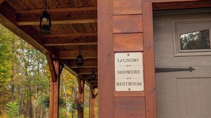Eine Holzhütte mit einem Schild, das 'Wascherei, Duschen, Toilette' anzeigt.