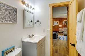 Une salle de bain équipée d’un lavabo, d’un miroir et d’un porte-serviettes.