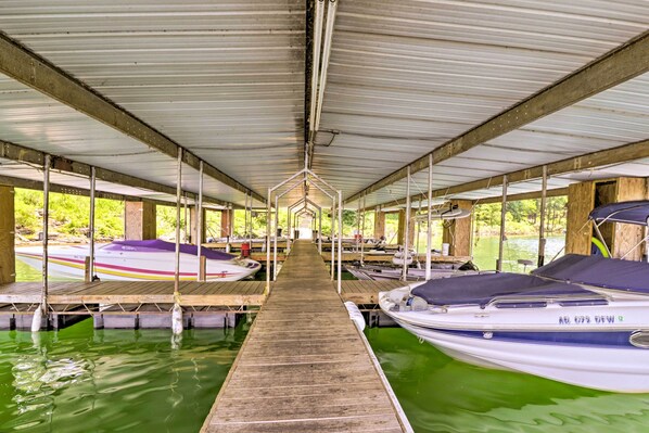 Un quai abrité, doté de plusieurs postes d’amarrage pour bateaux, de passerelles en bois et d’un espace central ouvert.