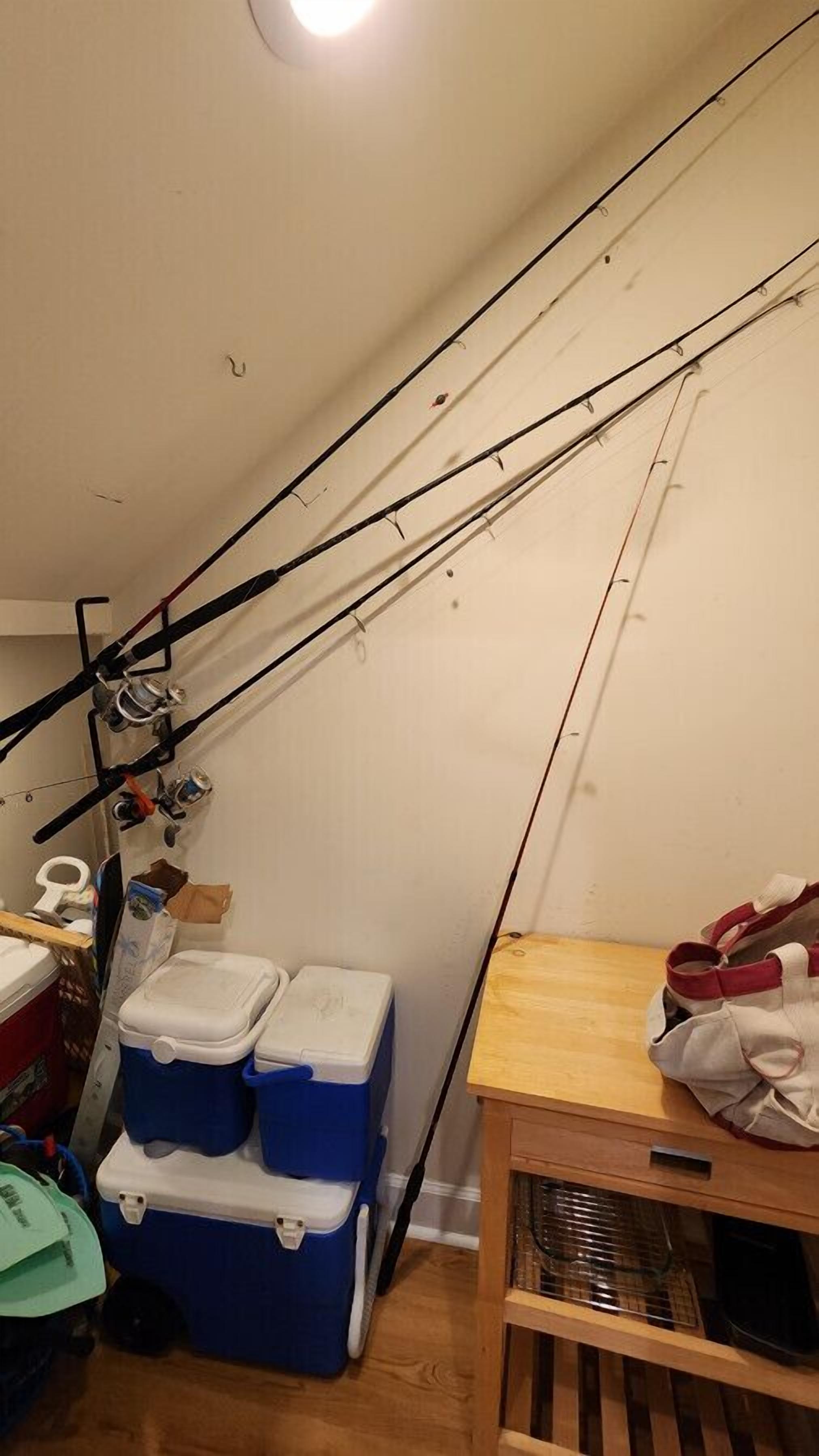 Quarto com varas de pesca, um cooler e um armário de madeira.