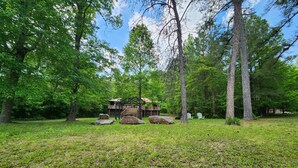 A cabin with a deck and stairs, surrounded by trees and rocks. - Cozy Cabin at Little River Canyon (Fort Payne)