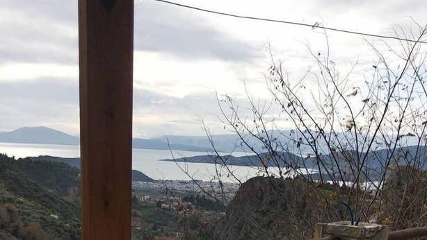A stone-paved terrace with a wooden railing overlooking a mountainous landscape and a body of water. - Small Detached House Of 60 M2 Situated In Koukourava, Makrinitsa In Pelion Mt. (Μακρινίτσα, Κουκουράβα)