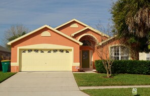 A single-story house with a garage, a front door, and a small front yard.
