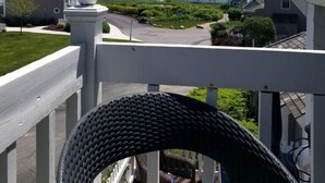 Ein Balkon mit Blick auf den Ozean und umliegende Häuser.