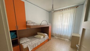 Un dormitorio con literas, un armario y una cortina.
