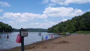 Ein Strandabschnitt mit einem Schild, das einen Schwimmbereich kennzeichnet.