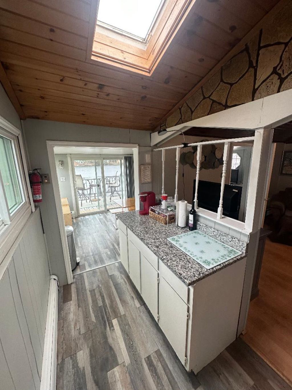 Una cocina con tragaluz, techo de madera y vistas al exterior.