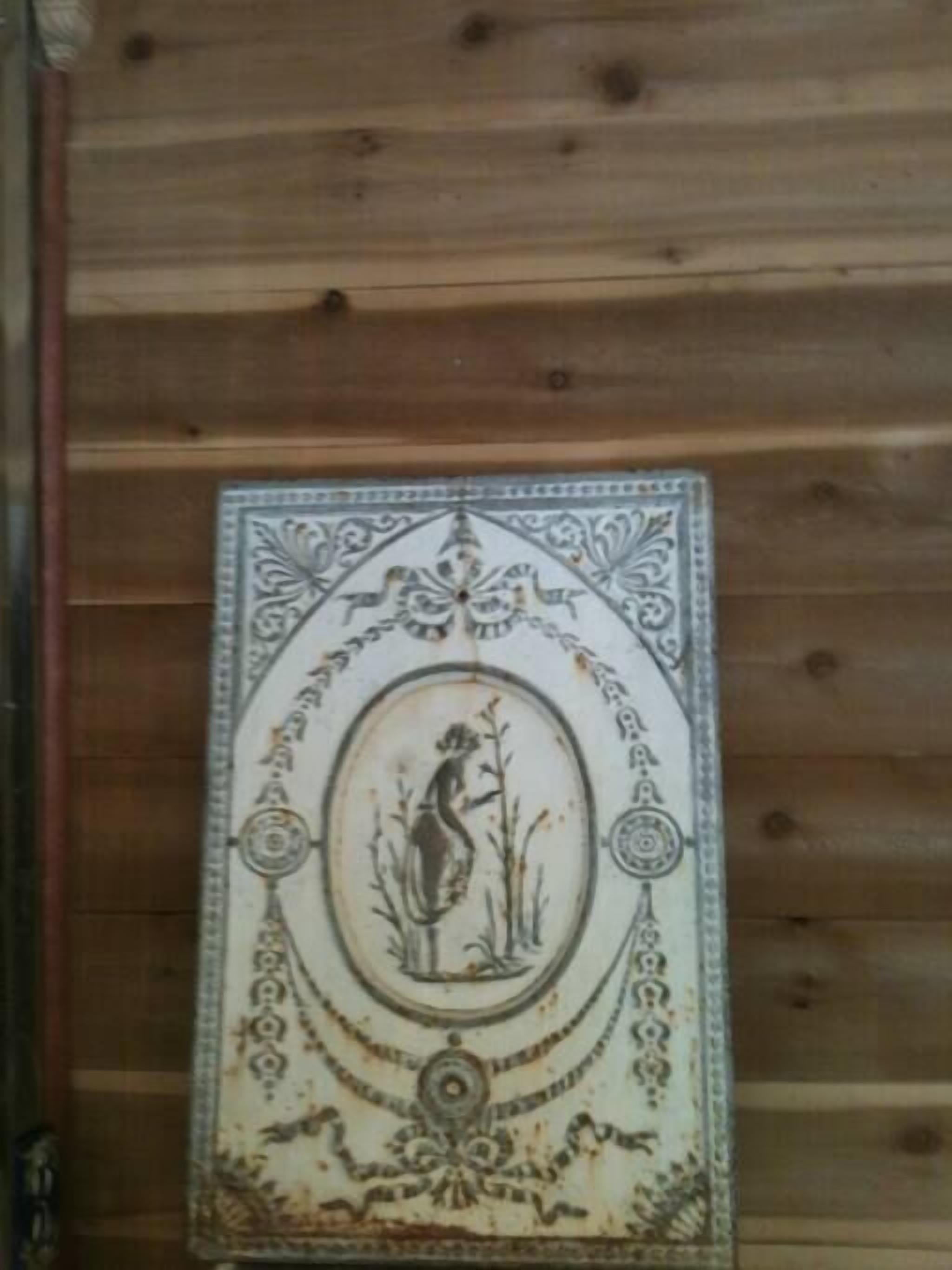 Un mur orné d’un panneau de carreaux décoratifs, avec une figure centrale et des motifs complexes.
