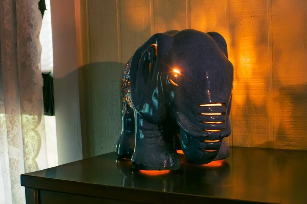 Una scultura a forma di elefante di colore scuro su un tavolo.