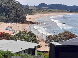 A beach with tents and a small building. - Fantastic Family Holiday Home with Breathtaking Views over Hot Water Beach (Hot Water Beach)