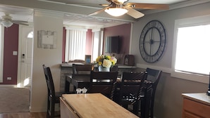 A dining area with a wooden table, chairs, and a ceiling fan.