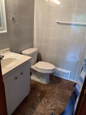 A bathroom with a toilet, sink, and shower area.
