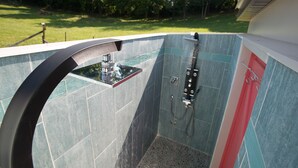 A modern shower with a glass enclosure, a handheld showerhead, and a handheld shower attachment. -  Modern country cottage that is dog friendly with a fenced-in yard.  (Columbia)