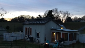 A single-story house with a covered porch, a fire pit, and a chair. -  Modern country cottage that is dog friendly with a fenced-in yard.  (Columbia)