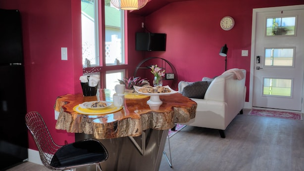 A dining area with a wooden island, a white sofa, and a door with windows. -  Modern country cottage that is dog friendly with a fenced-in yard.  (Columbia)
