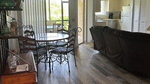 A kitchen with a dining area, a ceiling fan, and a view through the window.