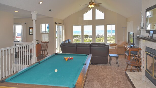 A pool table with balls, a sofa, and a television in a room with large windows and a view of the ocean. - Gathering Place overlooking beach, pier, and downtown Cayucos (Cayucos)