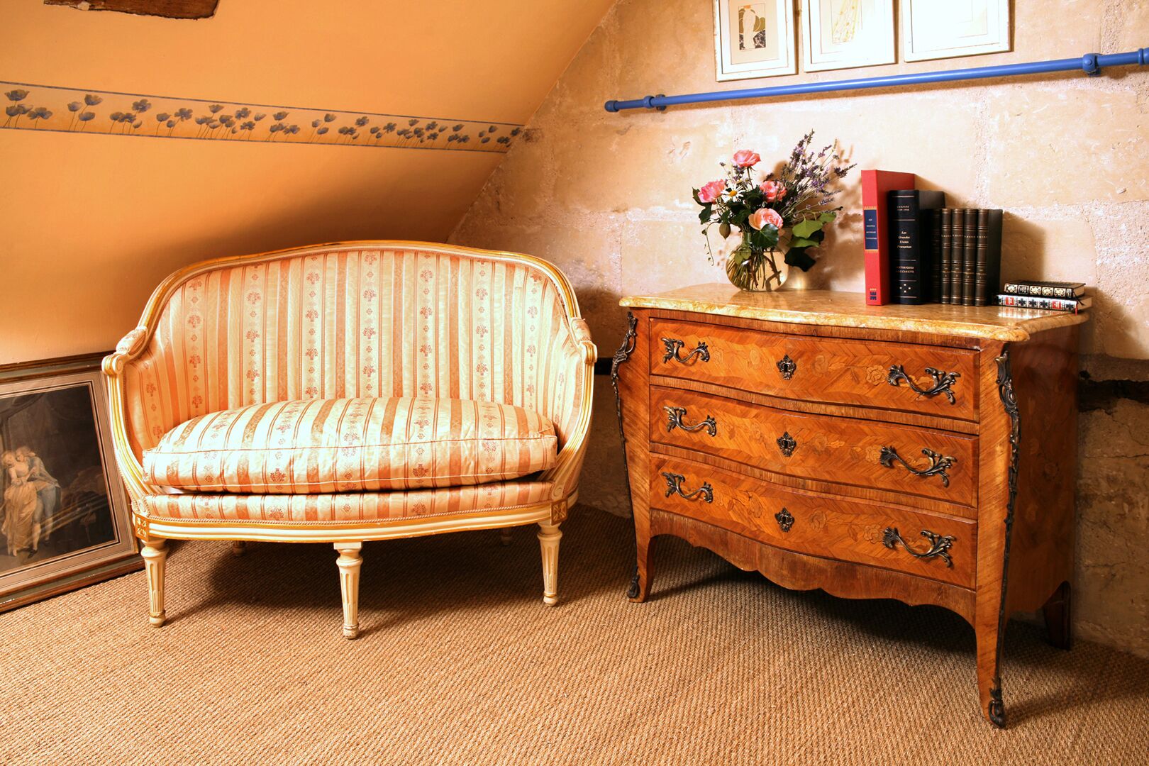 A room with a striped armchair and a wooden dresser with drawers.