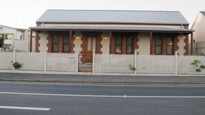 Een tweelaags huis met een witte picket-heining, een veranda en een garage.